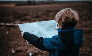 Little boy searching a map in a field in the New Forest United Kingdom